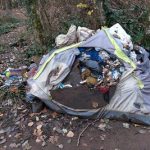 This old tent near the river became a trash receptacle