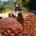 Amy Ray of Indigo Girls examines the native design of the memorial play structure. Photo credit: Camilla Mortensen.