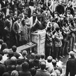 Photo of the Eugene Black Panthers speak on the UO campus in support of a Black student protest at Oregon State University in the late Sixties. From left to right: Oliver Patterson, Tommy Anderson (speaking), Howard Anderson, William Green, Jerome Foster, Julius Hurst, Dennis White, Darrell Fields, Teo DeRuso and Artie Cox.