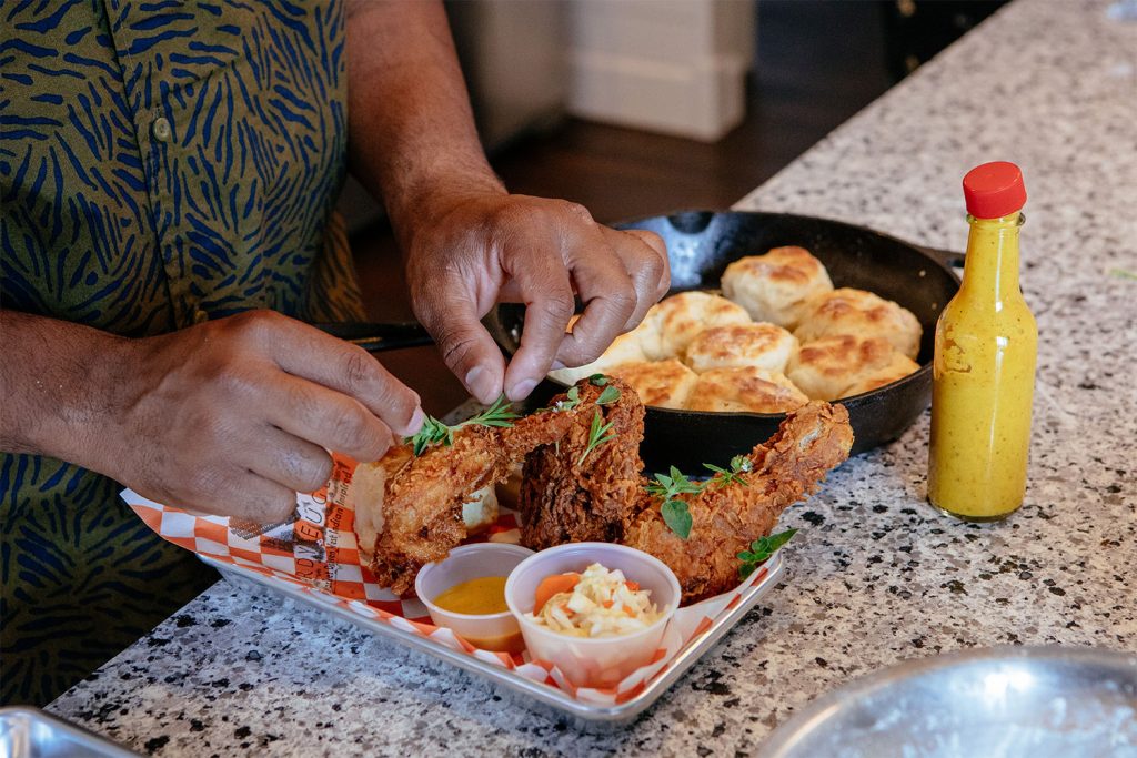 Chef Isaiah Martinez plates the skillet-fried chicken plate with salad, biscuits and pepper sauce.