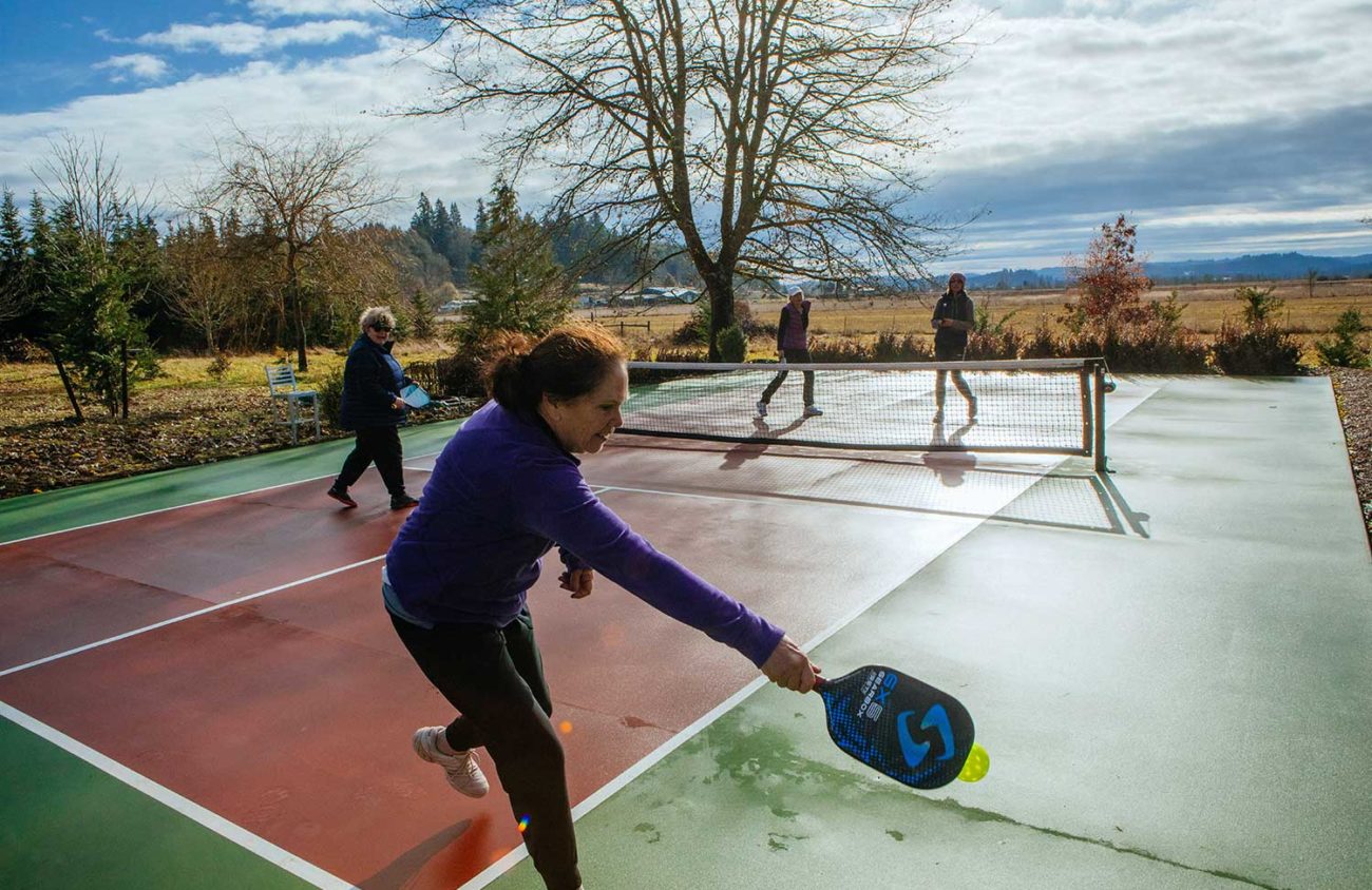 Pickleballers play a game on a personal backyard court near Fern Ridge Reservoir.