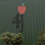 Logo for the 4J school district on the side of the district building