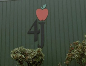 Logo for the 4J school district on the side of the district building
