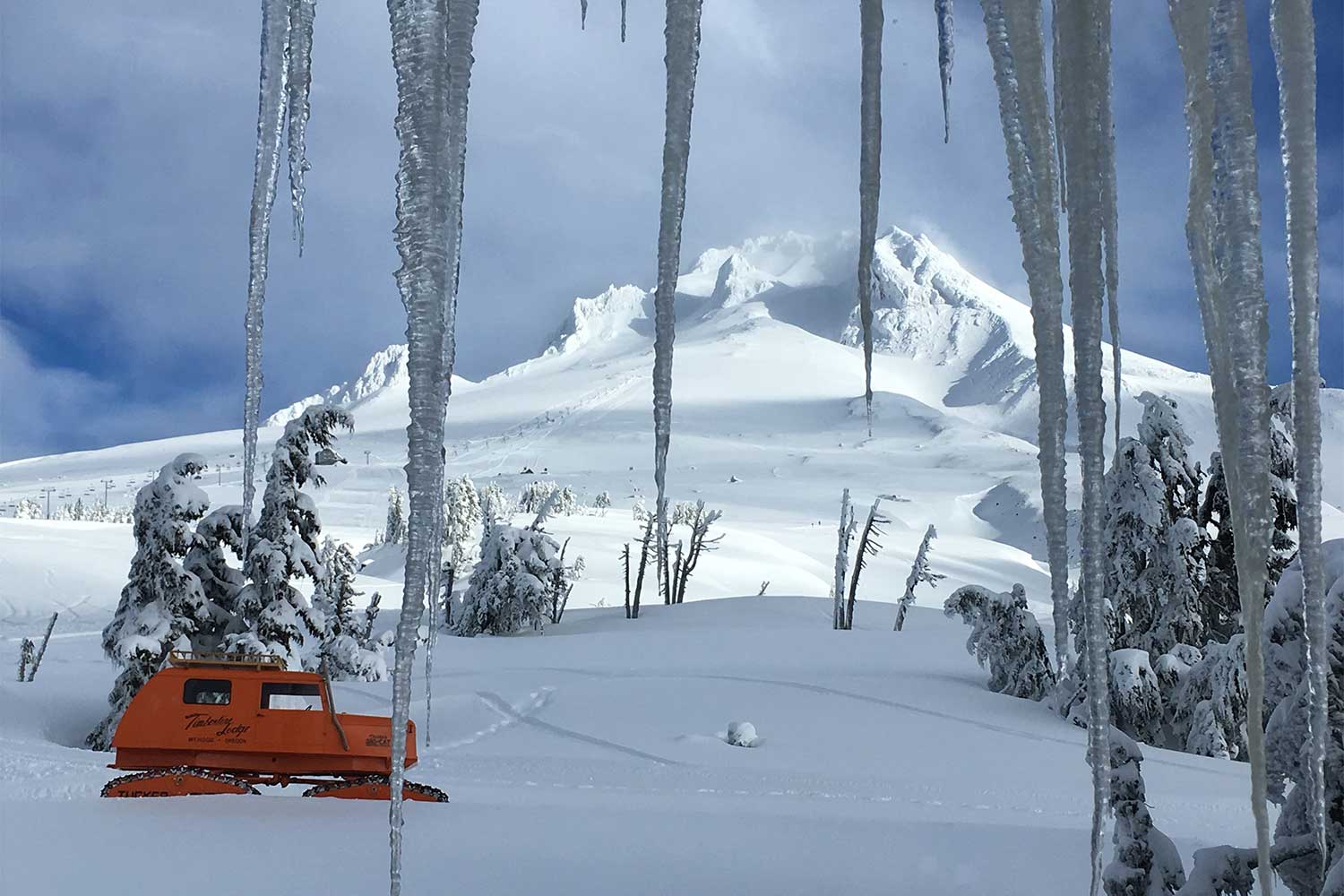 20241205outdoors-Timberline-Lodge-view-from-Rams-Head-Pub-of-Sno-Cat-with-icicles